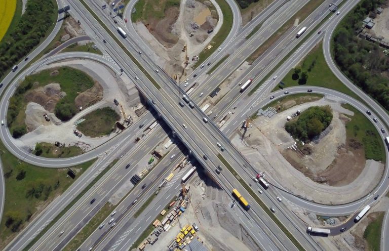 Autobahnkreuz von oben (Kinectra) Aerial view of a highway interchange under construction, showcasing kinetic energy recovery infrastructure for sustainable
transport.