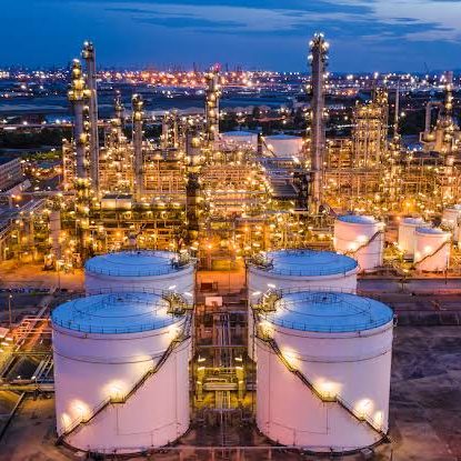 Raffinerie / Tanks bei Nacht Industrial refinery and storage facility at night, representing energy industry partnerships and infrastructure deployment.
